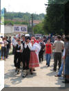 Tanečníci se řadí k slavnostnímu průvodu po vesnici